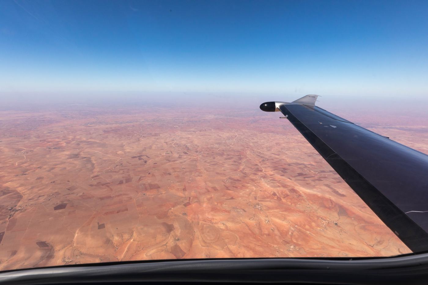 A PC-12 wing over the desert